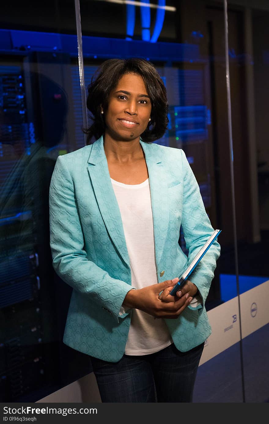 Woman in Teal Blazer Coat and Black Pants Holding A Tablet