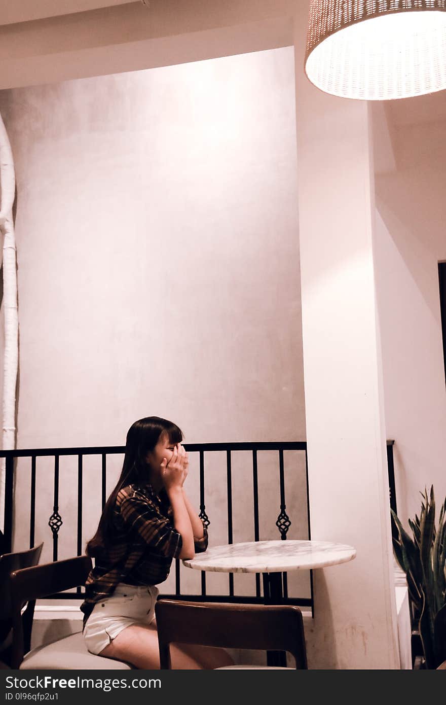 Woman Wearing Brown Plaid Dress Sitting on Chair