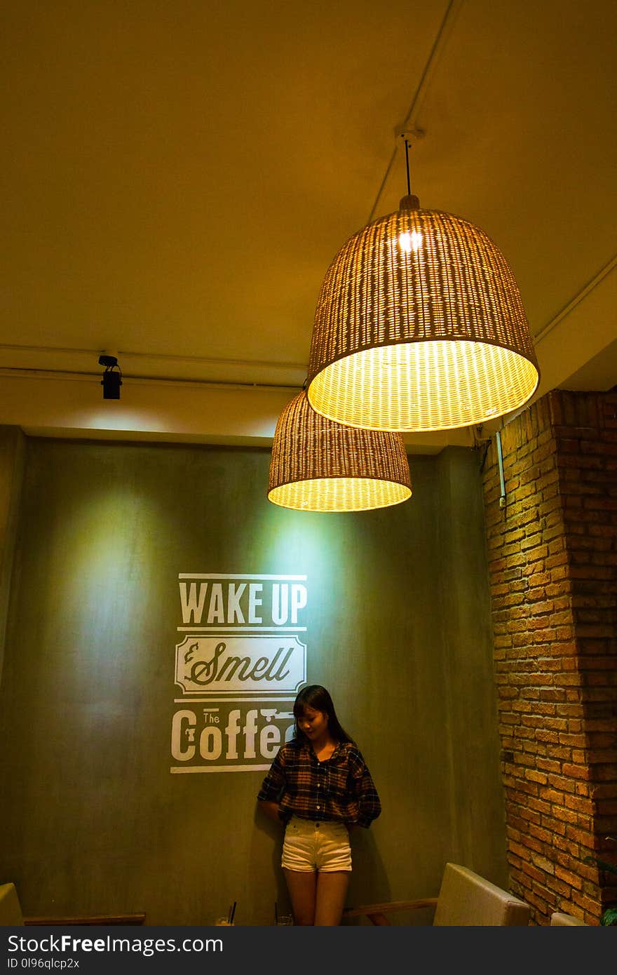 Woman Standing and Leaning Beside Wake Up Smell the Coffee Text Wall