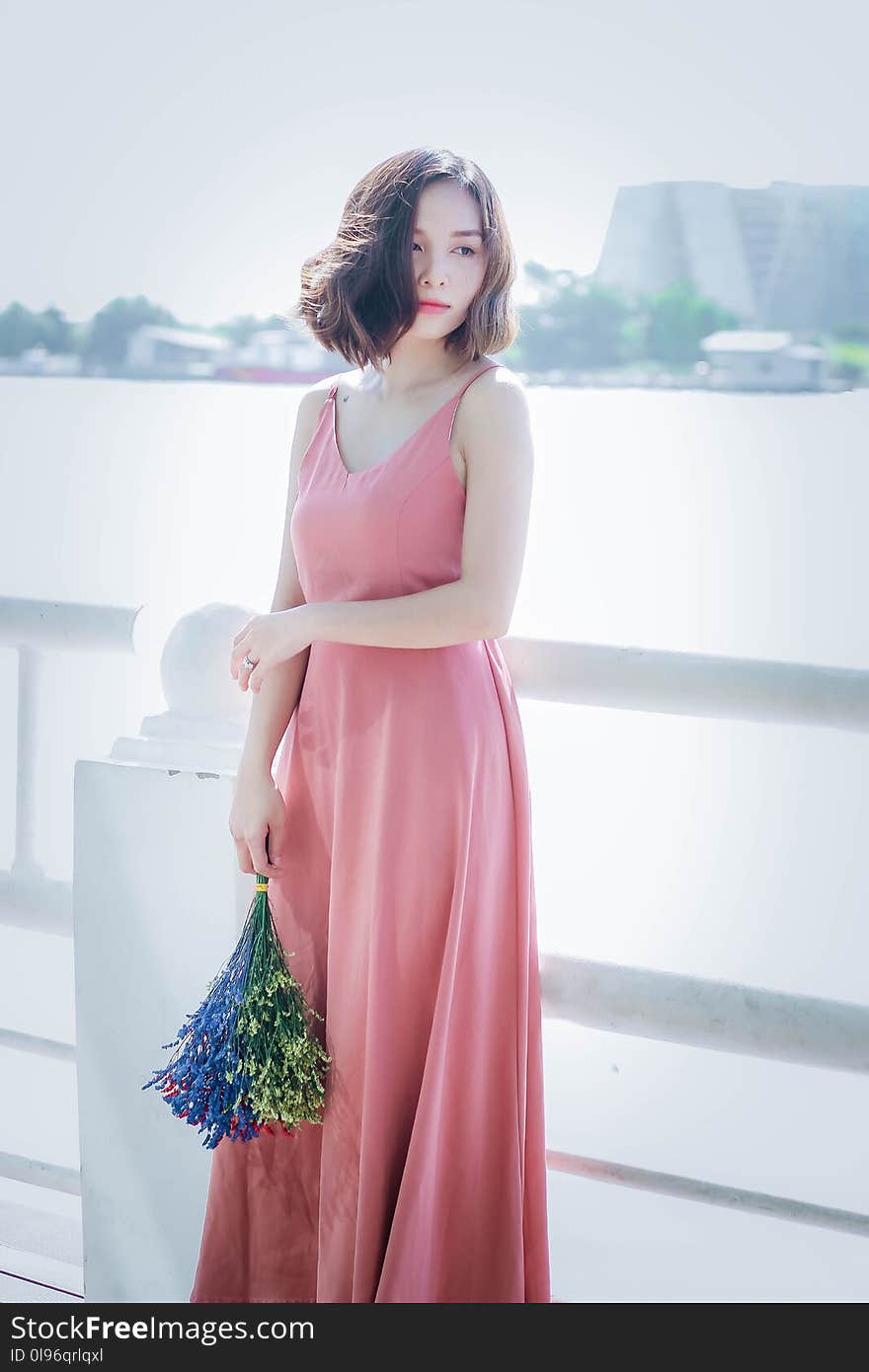 Woman Wearing Pink Spaghetti Strap Maxi Dress Holding Flowers