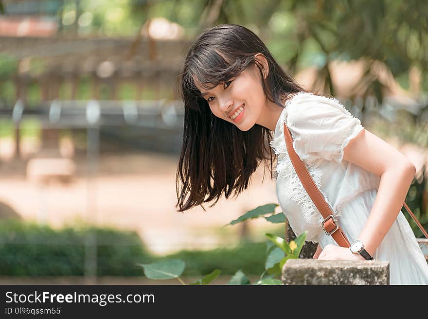 Photo of Woman in White Outfit Smiling.