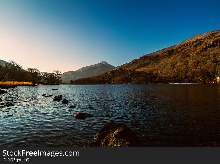 Landscape Photography of Body of Water Near Mountain