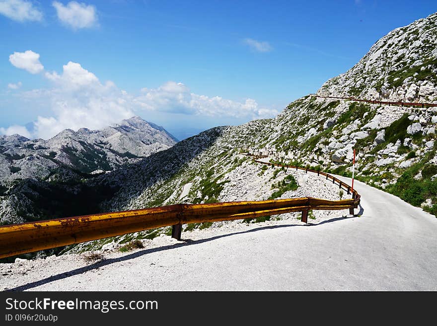 Photo of Narrow Paved Mountain Road with Barrier.