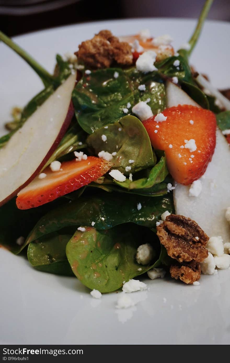 Sliced Strawberry And Green Leaf Vegetables On White Ceramic Plate