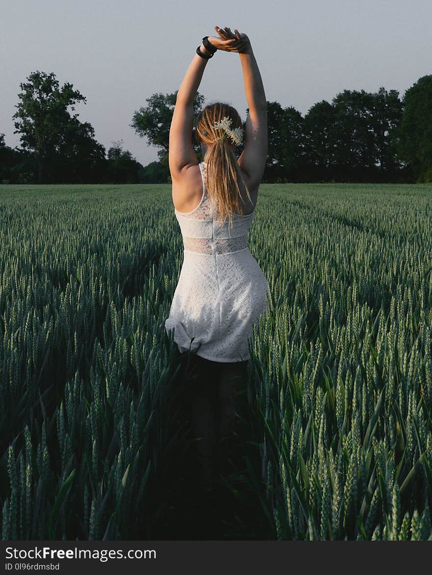 Woman Wearing White Lace Dress With Hands Raised Above Head