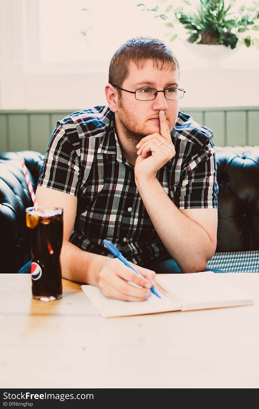 Man Wearing Black Plaid Shirt Sitting