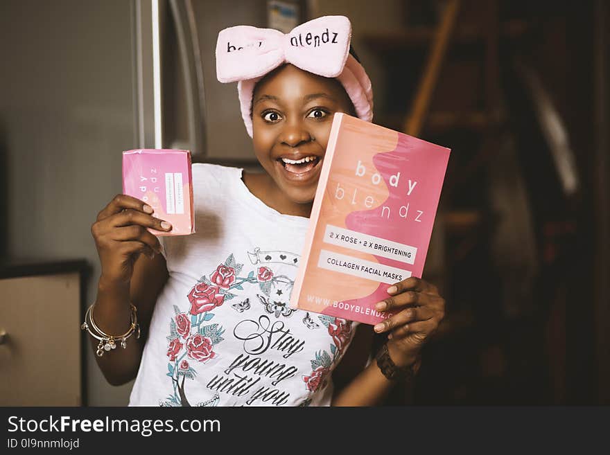 Woman Holding Book and Pink Box