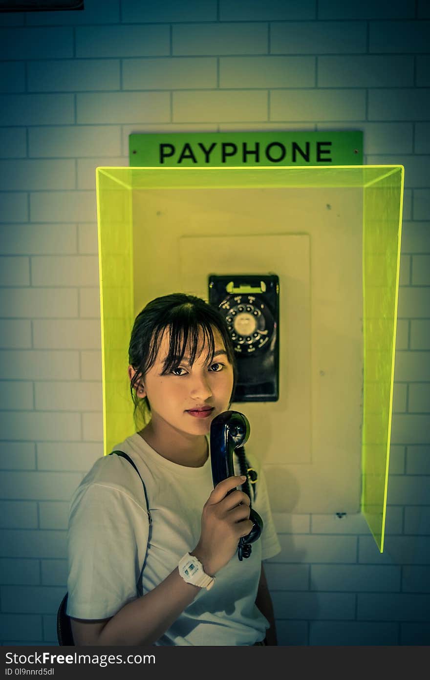 Woman in White Shirt Holding Telephone