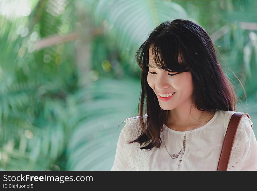 Photo of Woman Wearing White Outfit Smiling.