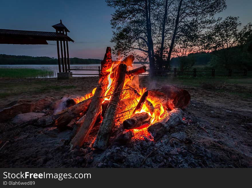 Calm bonfire at dusk by the lake in summer