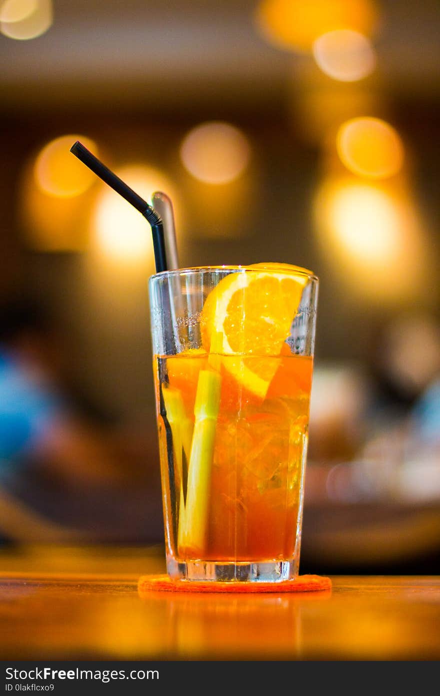 Clear Drinking Glass Filled With Orange Juice With Black Straw