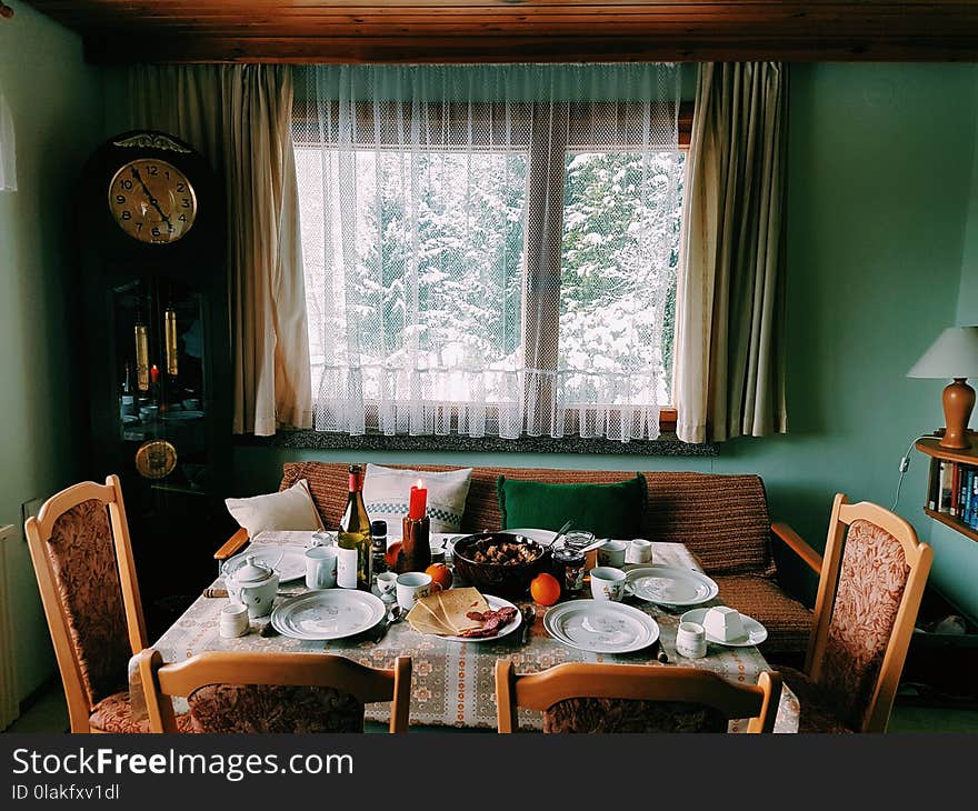 Arranged Table With Chairs and Plates Near Window