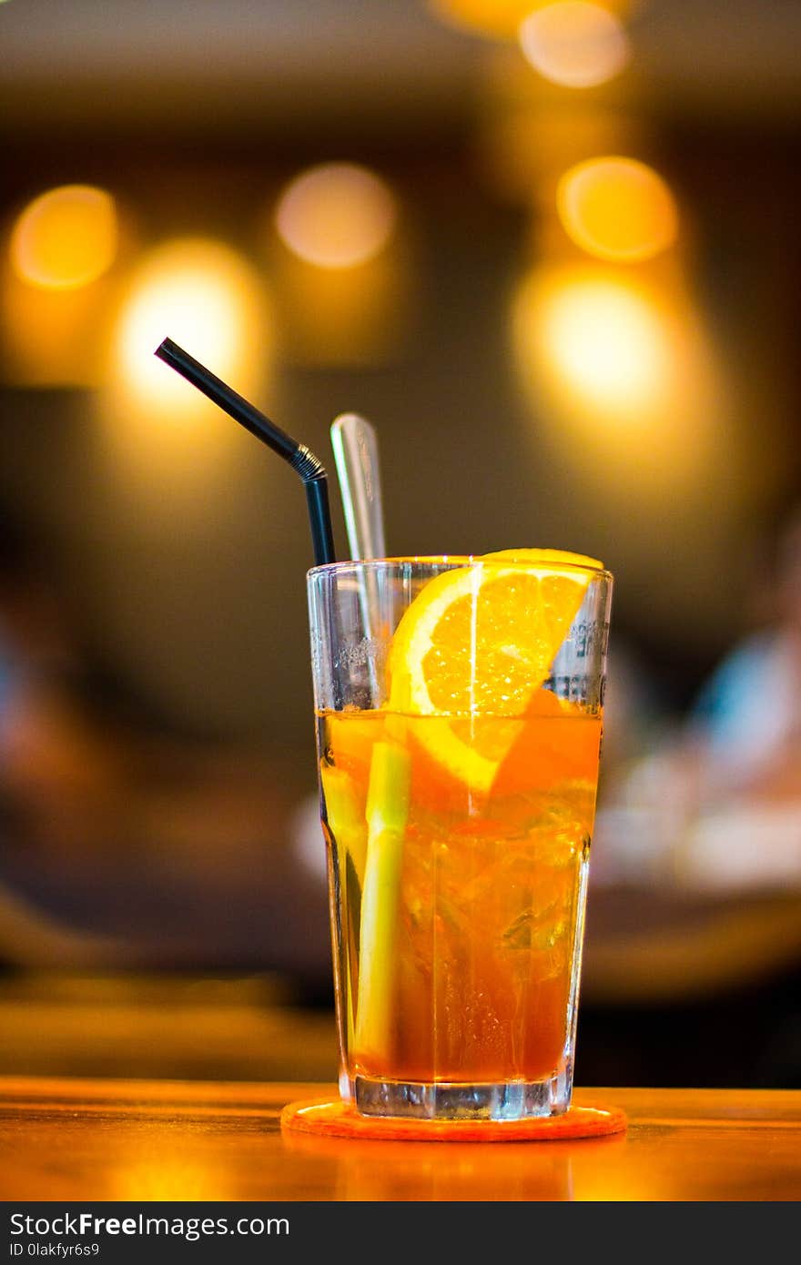 Macro Photography of Clear Drinking Glass With Lemon Fruit and Black Straw