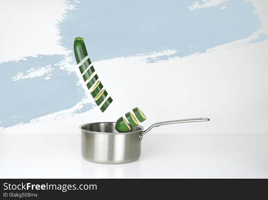 Gray Stainless Steel Sauce Pan and Green Cucumber Illustration