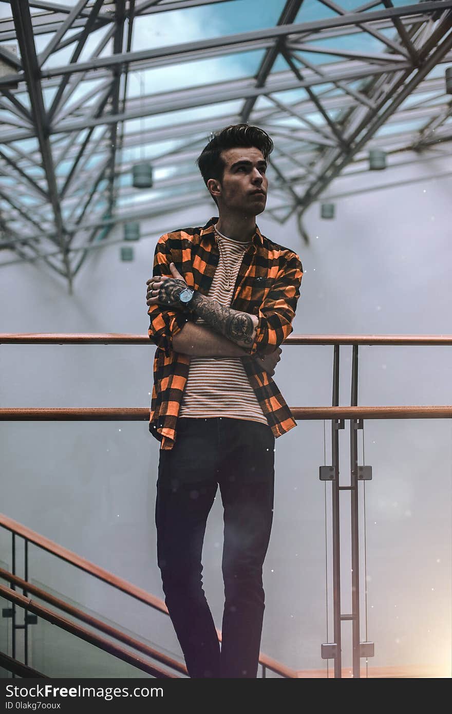 Man Standing on Brass Railing Looking Sideways