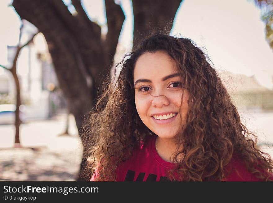 Selective Focus Photo of Woman Wearing Red and Black Crew-neck Top