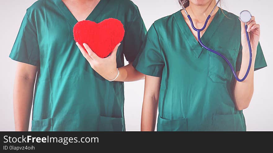 Doctor with stethoscope examining red heart