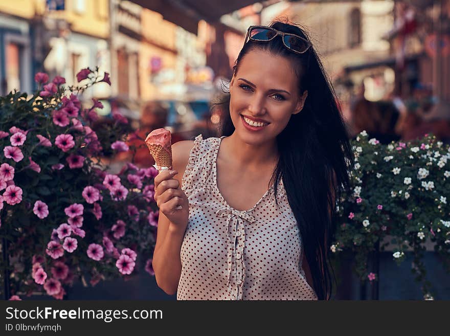 Happy Beautiful Brunette Girl Wearing Trendy Clothes Is Enjoying Summer Day Holds A Strawberry Ice Cream While Stands