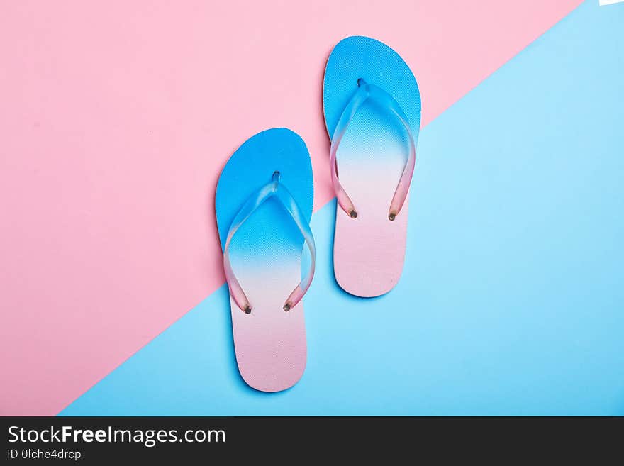 Stylish beach flip-flops on color background