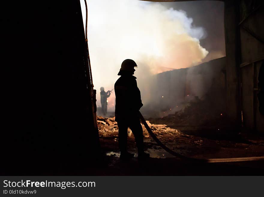 Silhouette Of Fireman Fighting Bushfire At Night