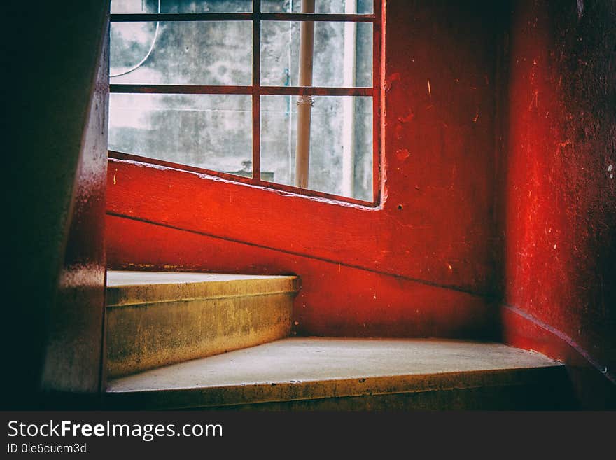 Steps of a spiral staircase with red and white walls.