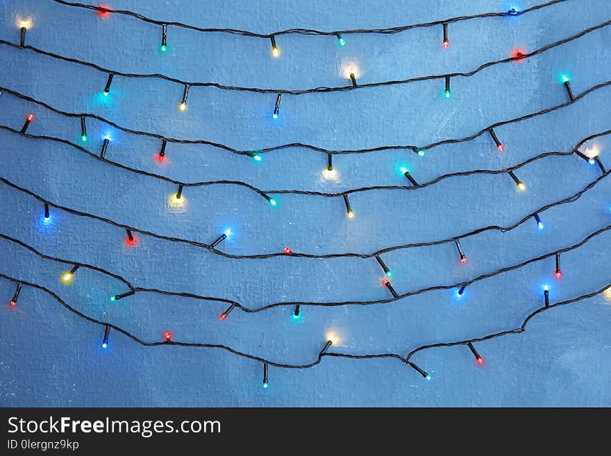 Beautiful bright Christmas lights on color background