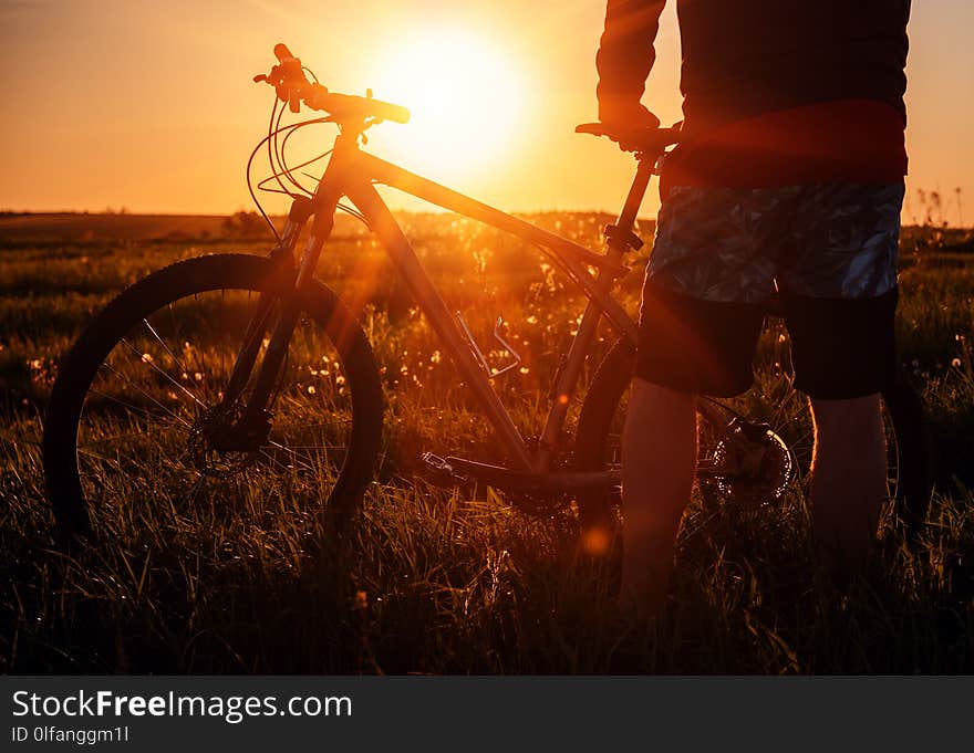 Man with bicycle on sunset