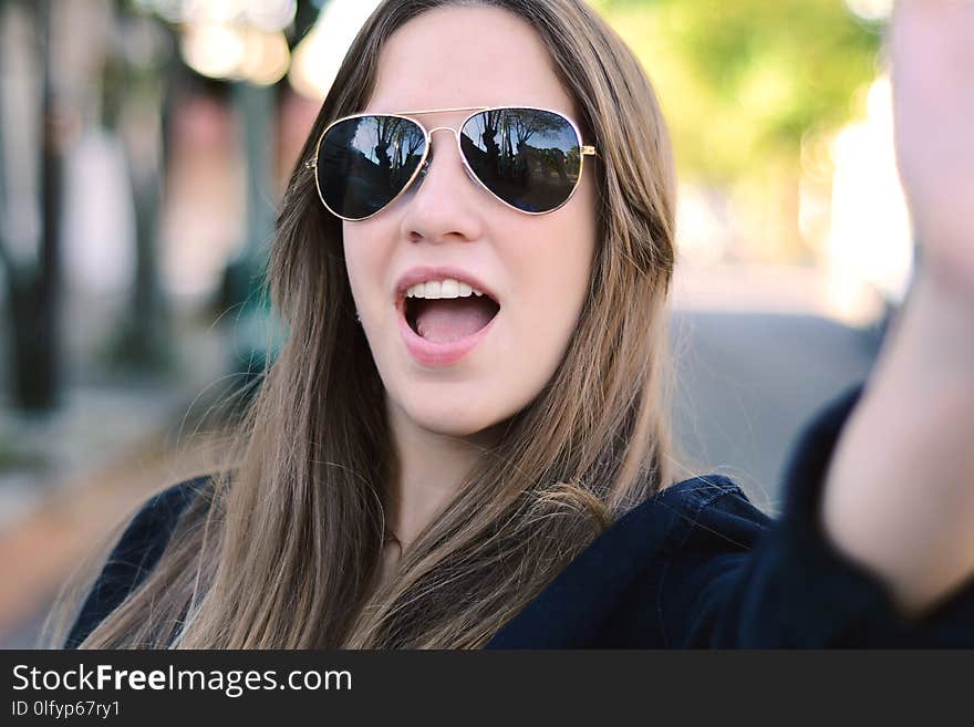 Portrait of young woman taking selfie.