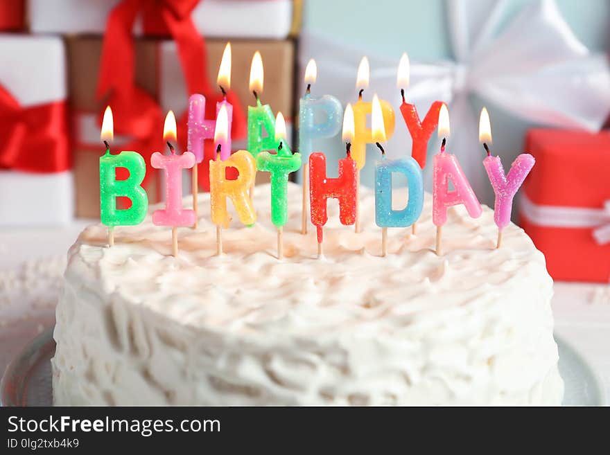 Delicious birthday cake with burning candles, closeup