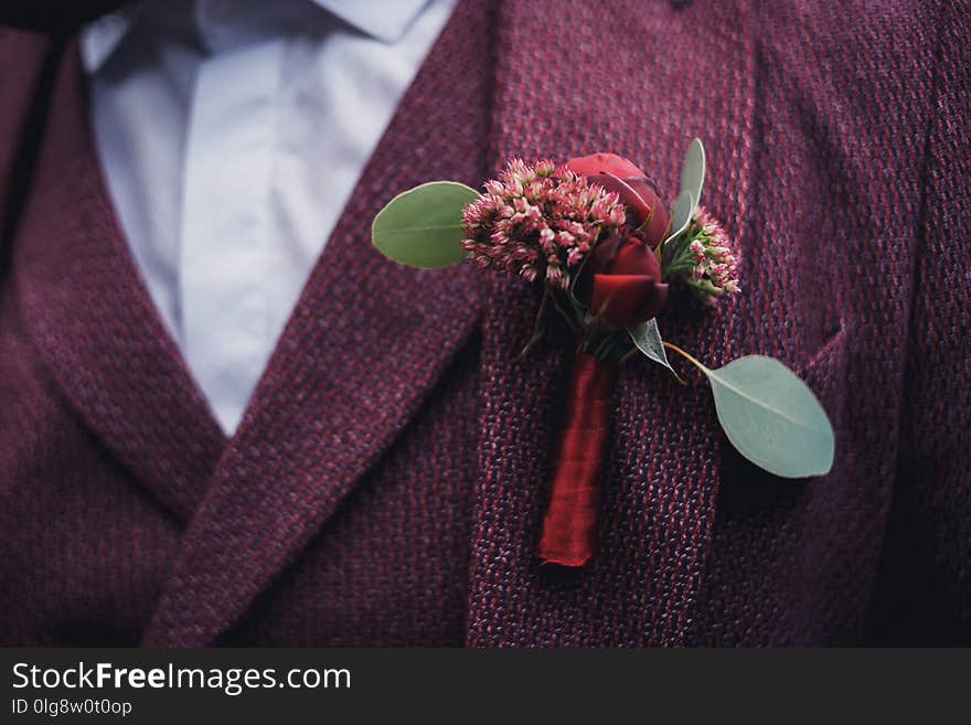 Groom and his boutonniere with a red ribbon. the jacket is dusty purple. wedding details. Groom and his boutonniere with a red ribbon. the jacket is dusty purple. wedding details