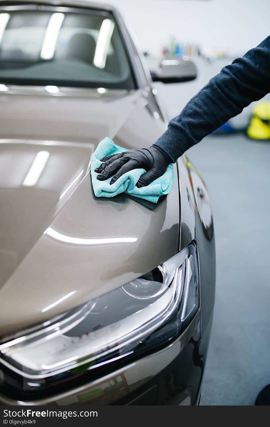 A man cleaning car with cloth, car detailing or valeting concept. A man cleaning car with cloth, car detailing or valeting concept.