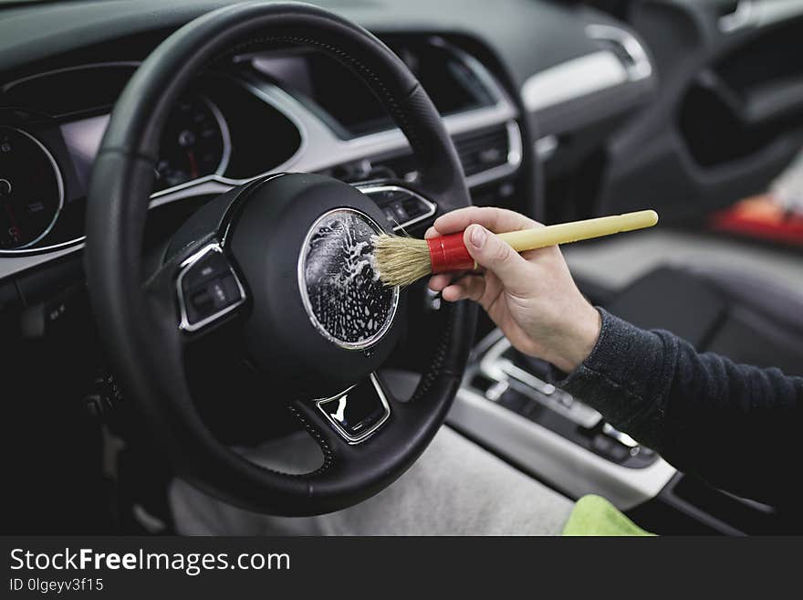 A man cleaning car interior, car detailing or valeting concept. A man cleaning car interior, car detailing or valeting concept.