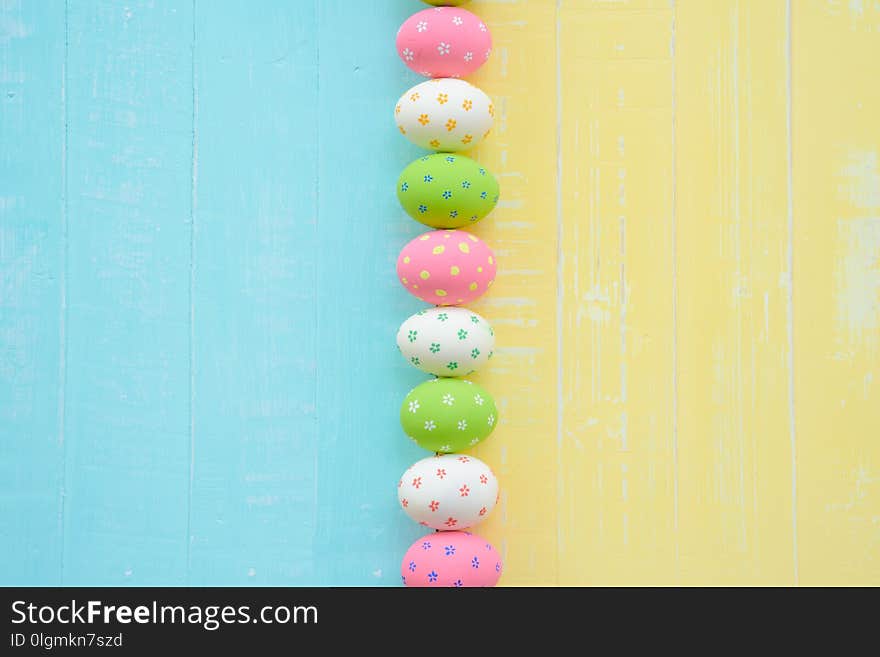 Happy easter! Row Easter eggs with colorful paper flowers on bright blue and yellow wooden background. Happy easter! Row Easter eggs with colorful paper flowers on bright blue and yellow wooden background.