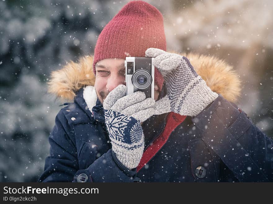 Young man with vintage photo camera in nature. Winter scene background. Young man with vintage photo camera in nature. Winter scene background.