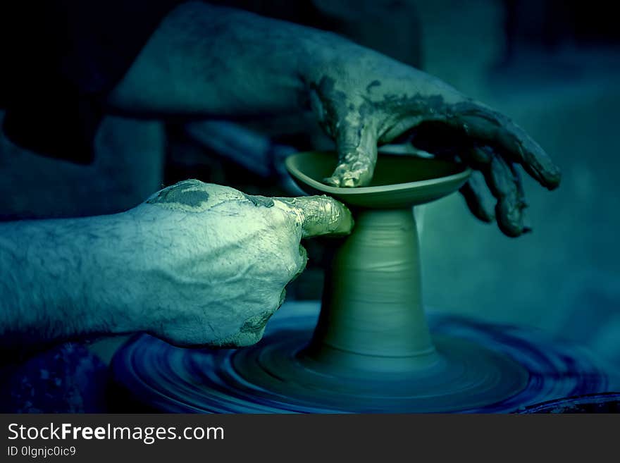 Potter working with clay, detail of a craftsman working in the city