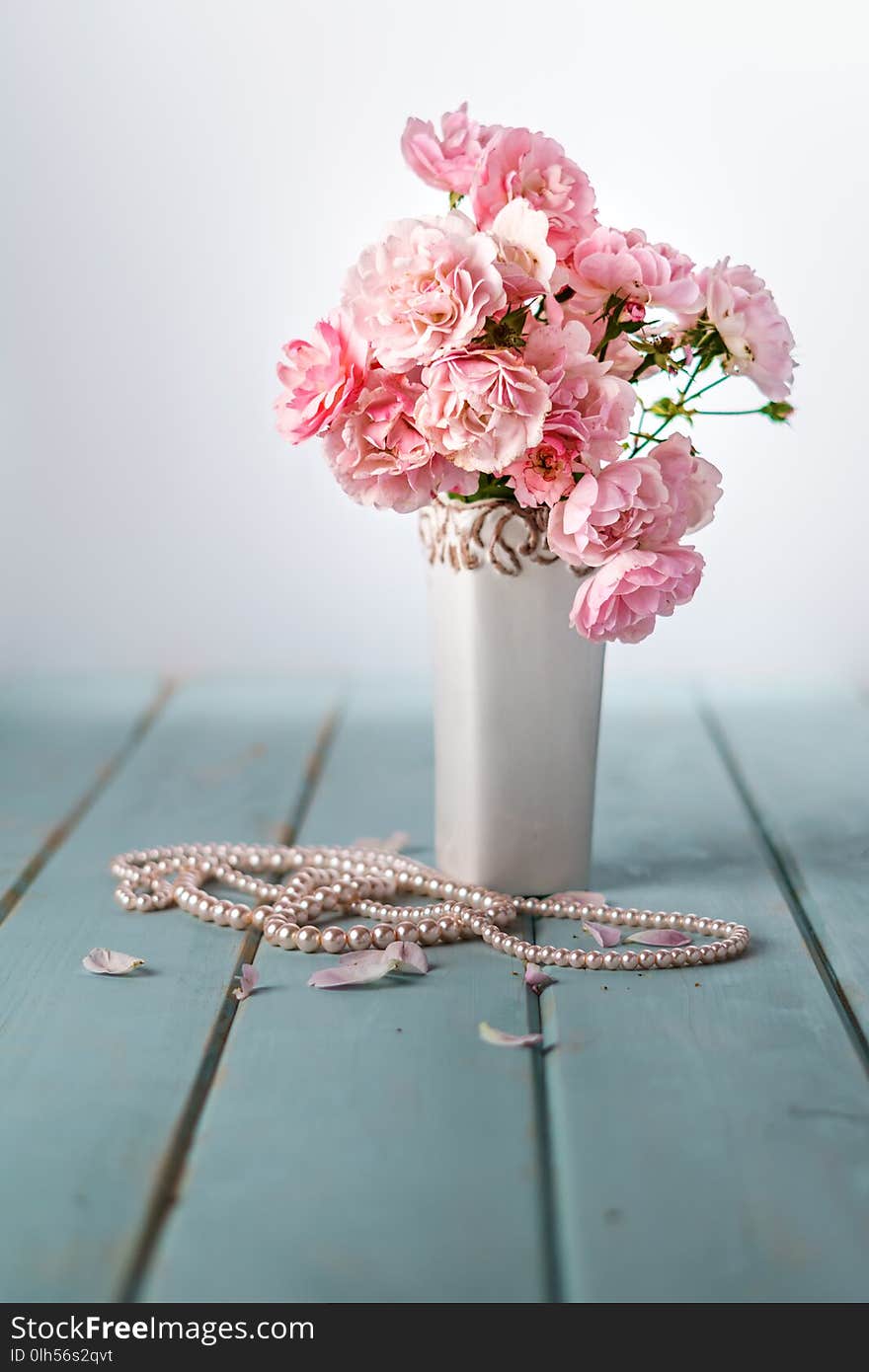 Vase with beautiful pink flowers on table.