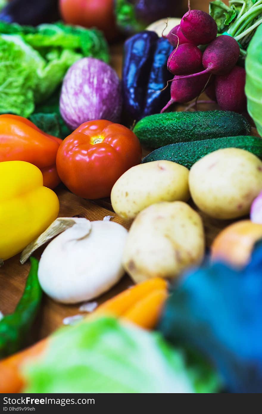 Vegetable assortment of different fresh vegetables on a wooden table top view. Ingredients for salads and light vegetarian snacks. Whole juicy fresh harvest from the farm. Soft focus. Vegetable assortment of different fresh vegetables on a wooden table top view. Ingredients for salads and light vegetarian snacks. Whole juicy fresh harvest from the farm. Soft focus.