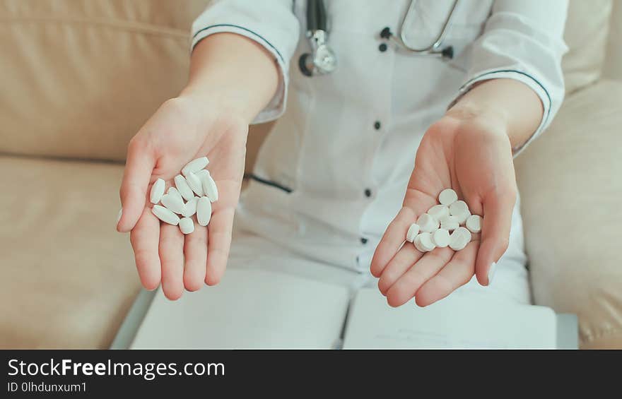 A Female Doctor In Her Hands Holds Many White Pills