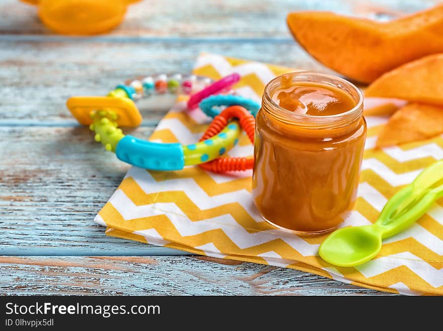 Jar with healthy baby food on table