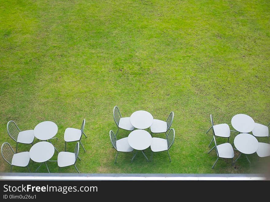 Top view of table and chairs on garden terrace at cafe.