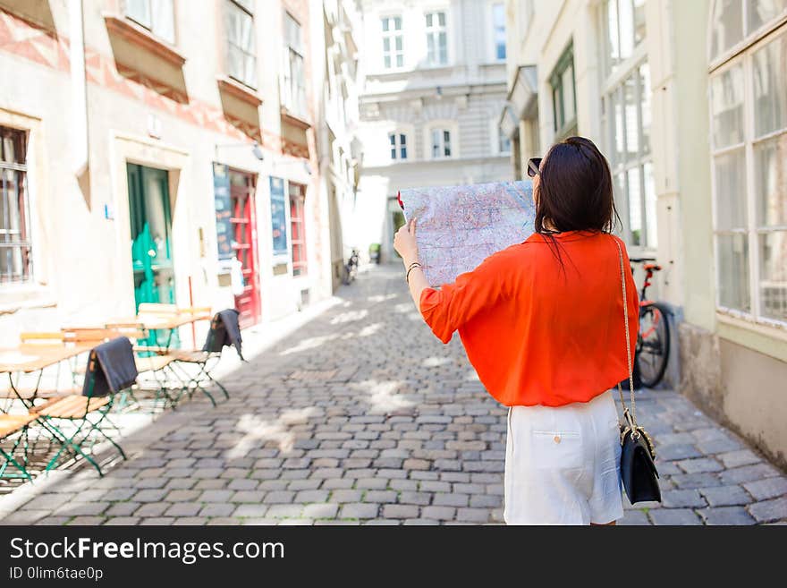 Young woman with a city map in city. Travel tourist girl with map in Vienna outdoors during holidays in Europe.