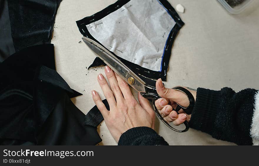 Girl modeler cuts a scissor pattern on the fabric. Shooting close-up. Girl modeler cuts a scissor pattern on the fabric. Shooting close-up.