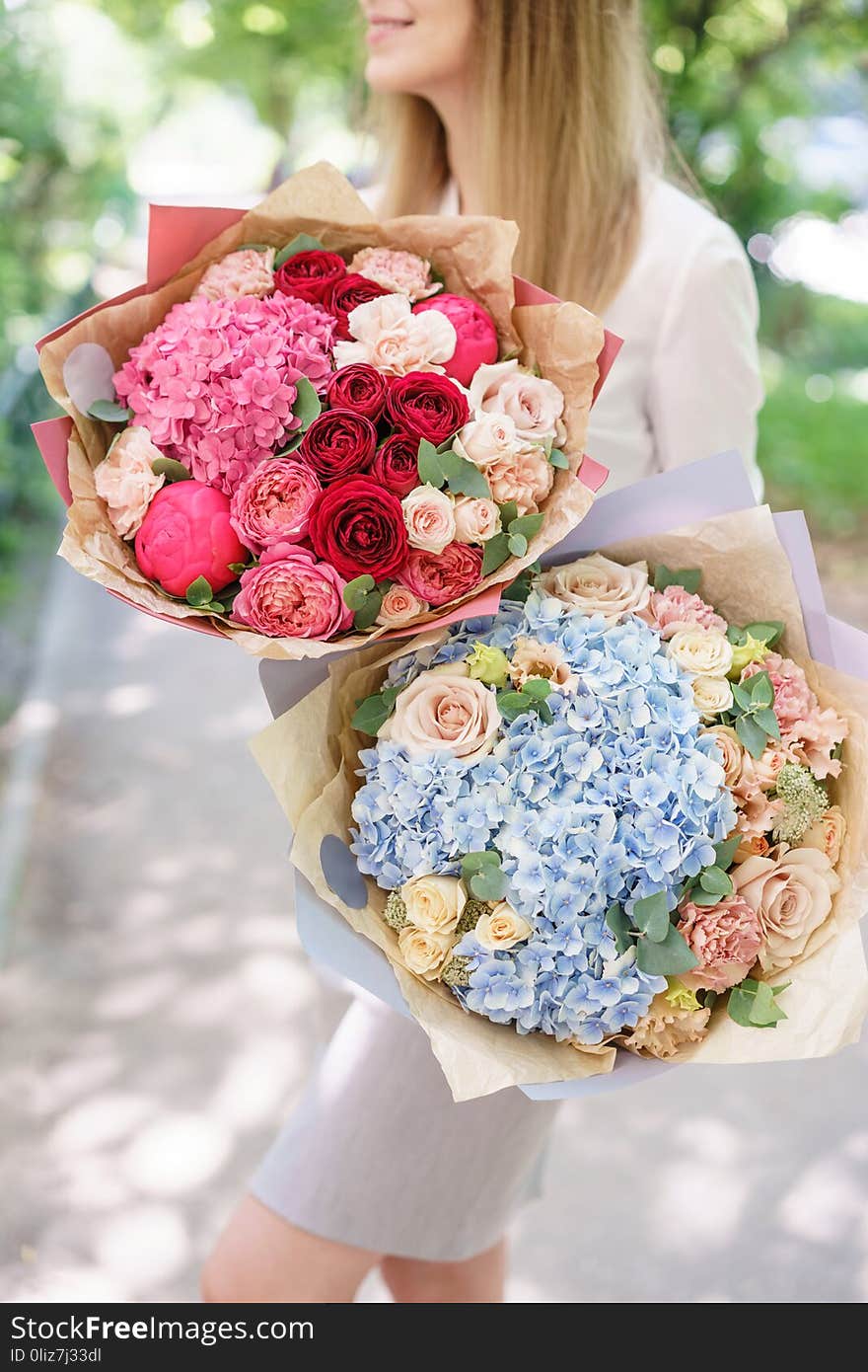 Beautiful summer bouquet. Arrangement with mix flowers. Young girl holding a flower arrangement with hydrangea. The concept of a flower shop. Beautiful summer bouquet. Arrangement with mix flowers. Young girl holding a flower arrangement with hydrangea. The concept of a flower shop.