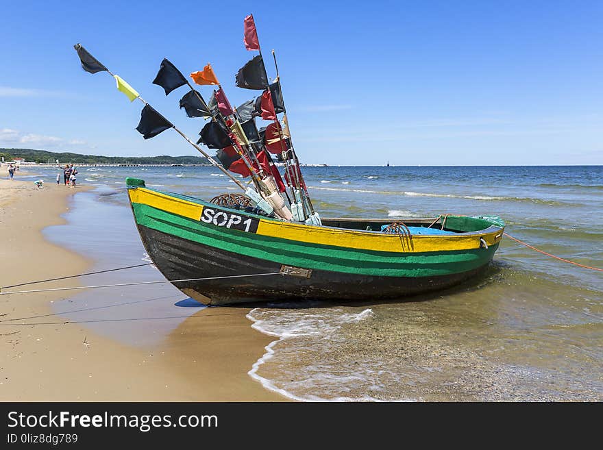 Fishing boats by the sandy beach on the Baltic Sea on a sunny day, Sopot, Poland.