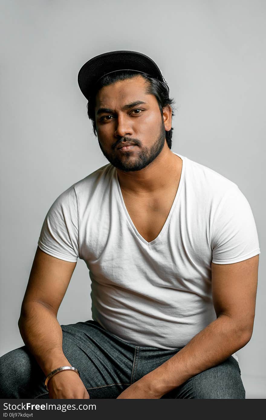 Close up photo of Hindu muscular man in fashion clothes isolated on the white background. indian rapper