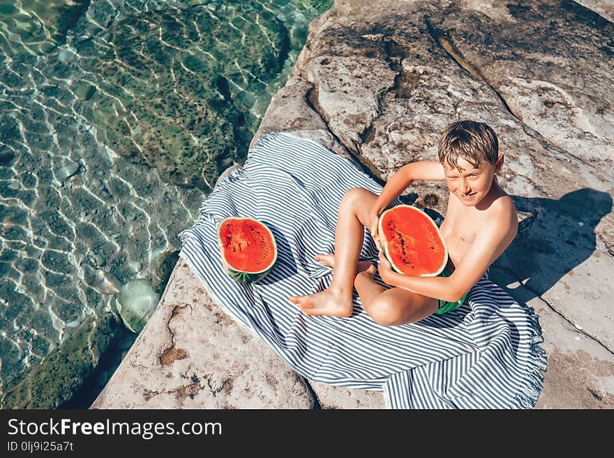 Summer plesuares: boy ready to eat big watermelon after swimming