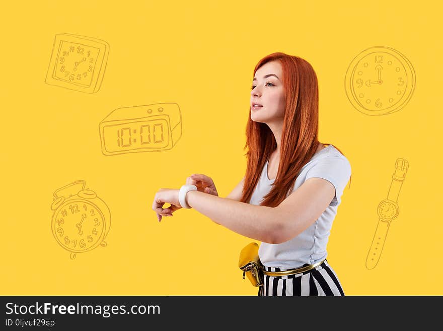 Be in time. Calm clever young student using her convenient modern smart watch while checking the time before the lecture. Be in time. Calm clever young student using her convenient modern smart watch while checking the time before the lecture