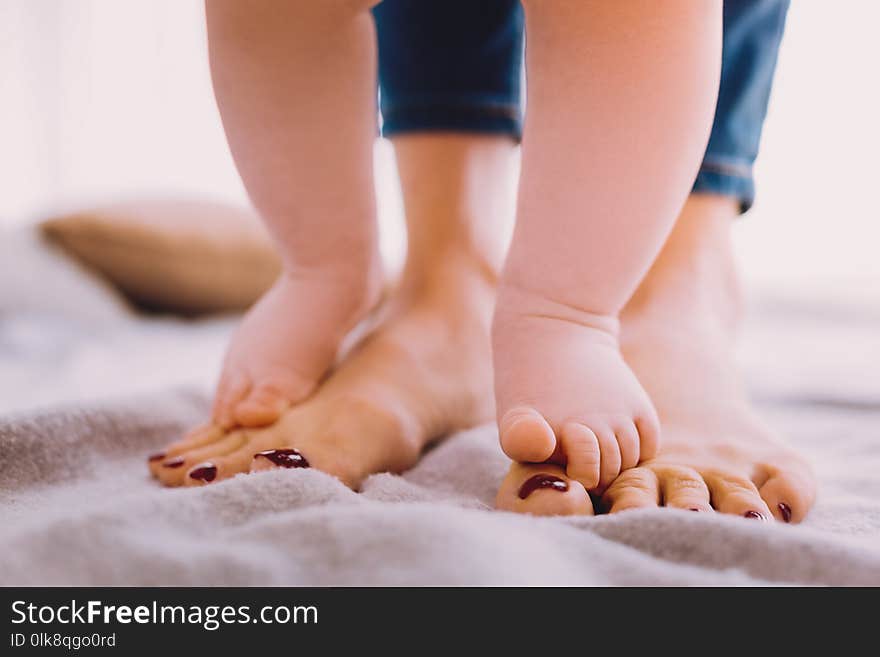 Cute baby standing on the feet of a mother and finding balance