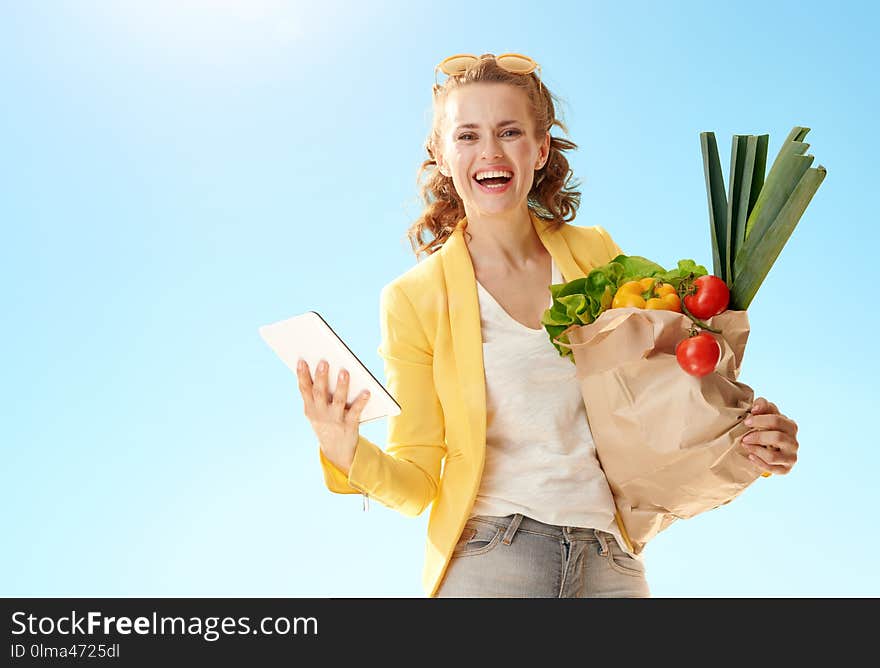 Woman with paper bag with groceries with tablet PC again