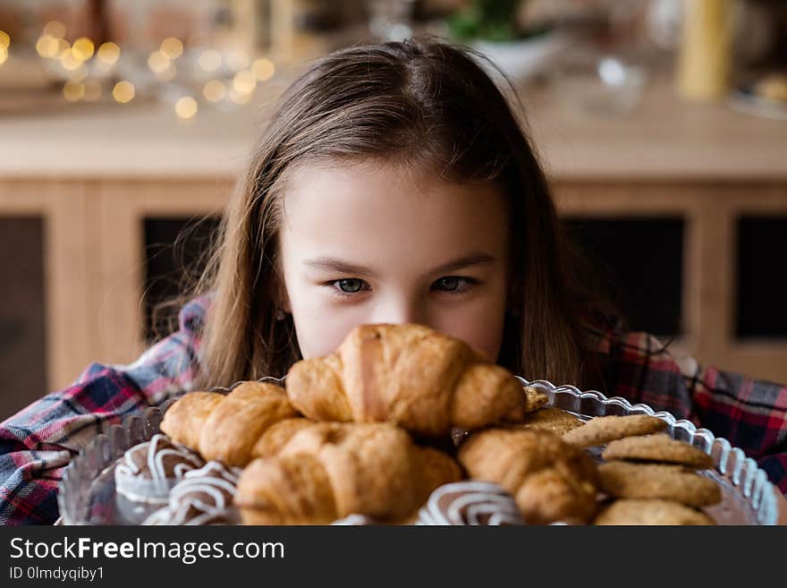 Child nutrition problems. unhealthy eating habits. pastry temptation. little girl is in love with croissants. Child nutrition problems. unhealthy eating habits. pastry temptation. little girl is in love with croissants